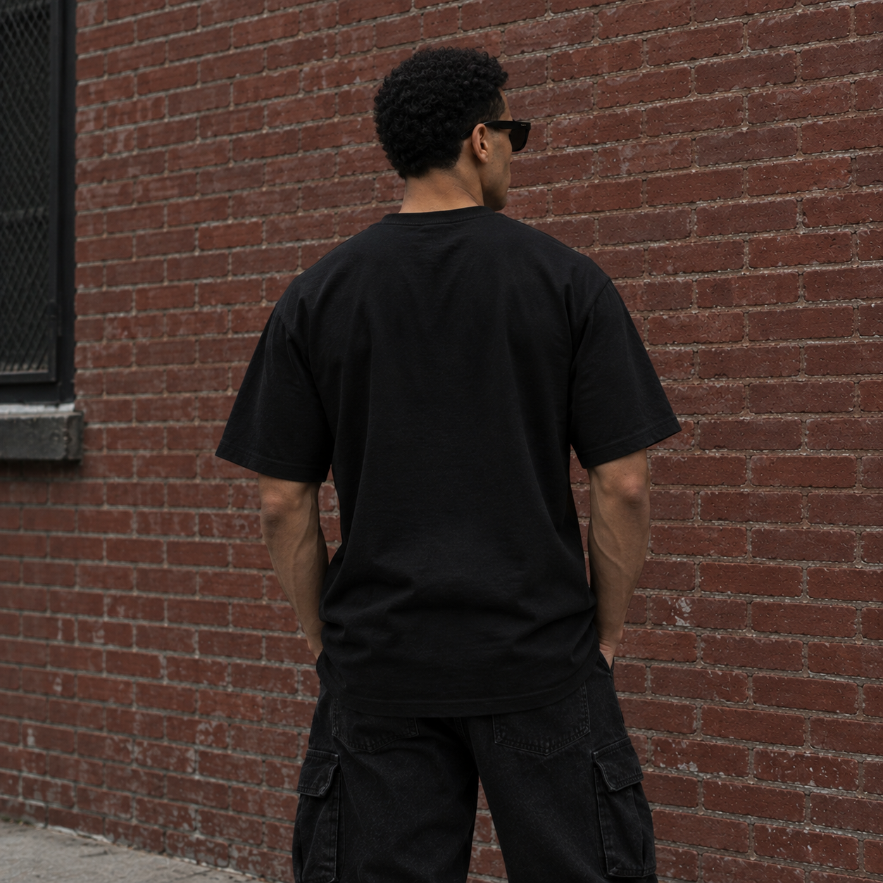 Model wearing black full chest logo streetwear tee, back view