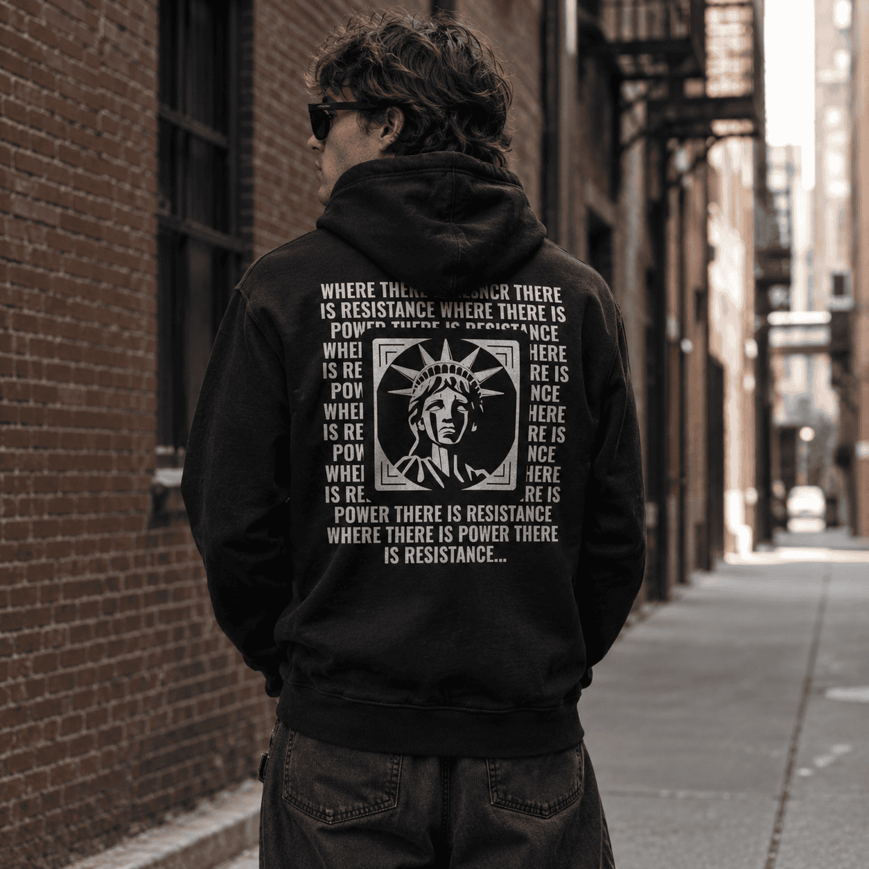 Model wearing a black protest quote, where there is power there is resistance hoodie